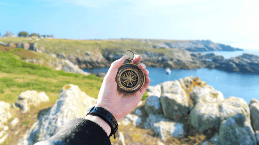 Boussole devant un bord de mer roquailleux